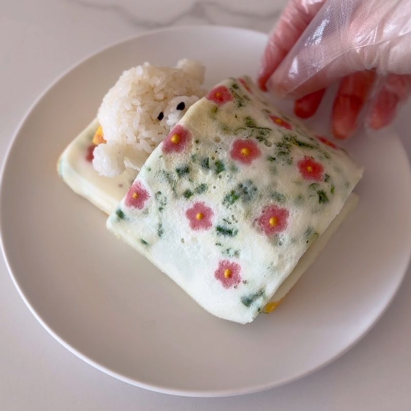 その上にビションフリーゼを寝かせ、卵焼きのお布団をかけてあげたら完成！